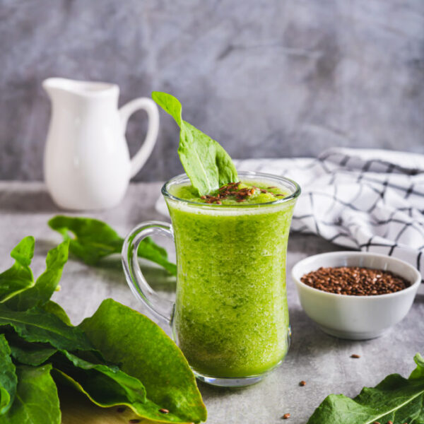 Refreshing smoothie made from sorrel leaves and flax seeds in a glass on the table vertical view