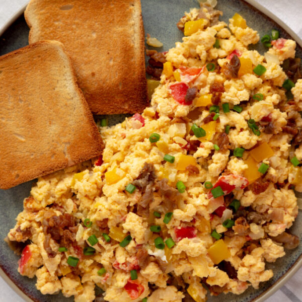 Homemade Fiesta Scrambled Eggs with Peppers and Toast on a Plate, top view. Flat lay, overhead, from above.