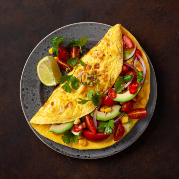 omelette with tomato, avocado onion chili and sweet corn. healthy keto diet low carb breakfast