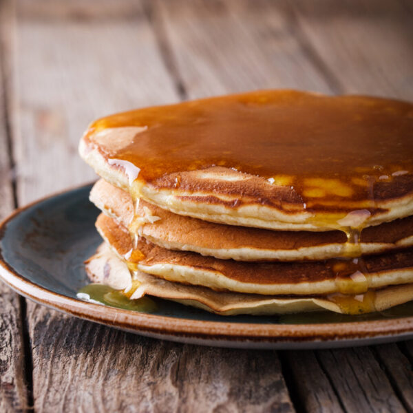 Pancake folded stack of with liquid honey on wooden background.selective focus.